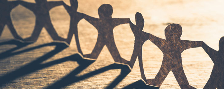Human chain paper with light and shadow on wood table